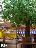 Ein großer Kunstbaum als Blickfang in einem Shoppingcenter
